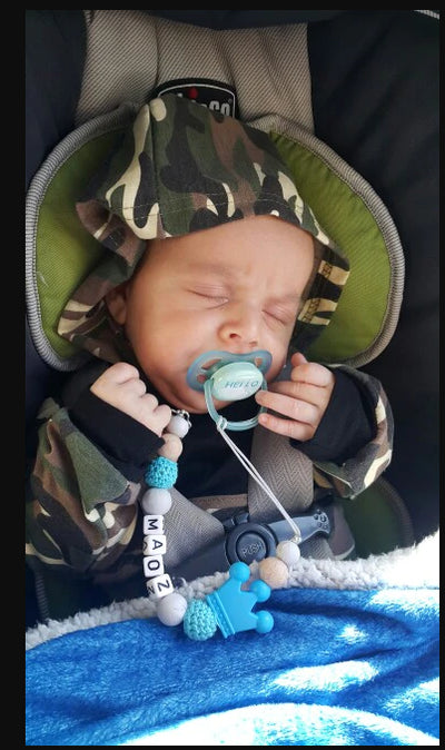 baby with pacifier clip and name on it