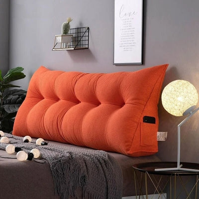 big thick headboard pillow in orange color with phone pocket on side